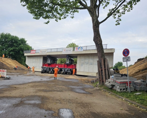 Brückeneinschub, Brückenbau, Krefeld, Autokrane Schares, Schwerlastlogistik, Schwertransport, SPMT, Cometto MSPE, Liebherr LTM 1230-5.1, Liebherr LTM 1650-8.1, Kraneinsatz, Einheben, Einfahren, Rahmenbauwerk, Infrastruktur, Heavy Load, Projektlogistik, Engineering, Brückenmontage, One-Stop-Shop, Mobilkran, Spezialtransport, Großkran, Fertigteilmontage, Verschubtechnik